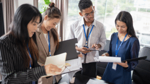 Team of business colleagues smiling and reviewing documents during a meeting.