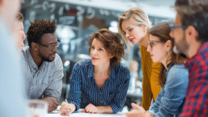 Group of diverse professionals discussing ideas during a meeting, focusing on digital marketing strategy.