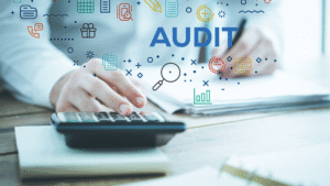 Person using calculator and writing notes with illustrated “AUDIT” icons representing data analysis.