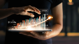 Hands holding a tablet displaying a glowing bar graph and upward growth curve representing digital marketing analytics.