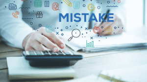 Close-up of person using a calculator with the word “Mistake” overlaid, symbolizing financial errors.